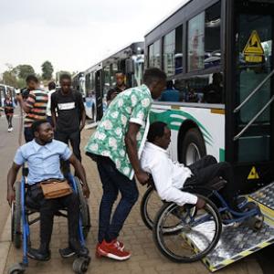 Image of people with disabilities in Rwanda getting on a bus.